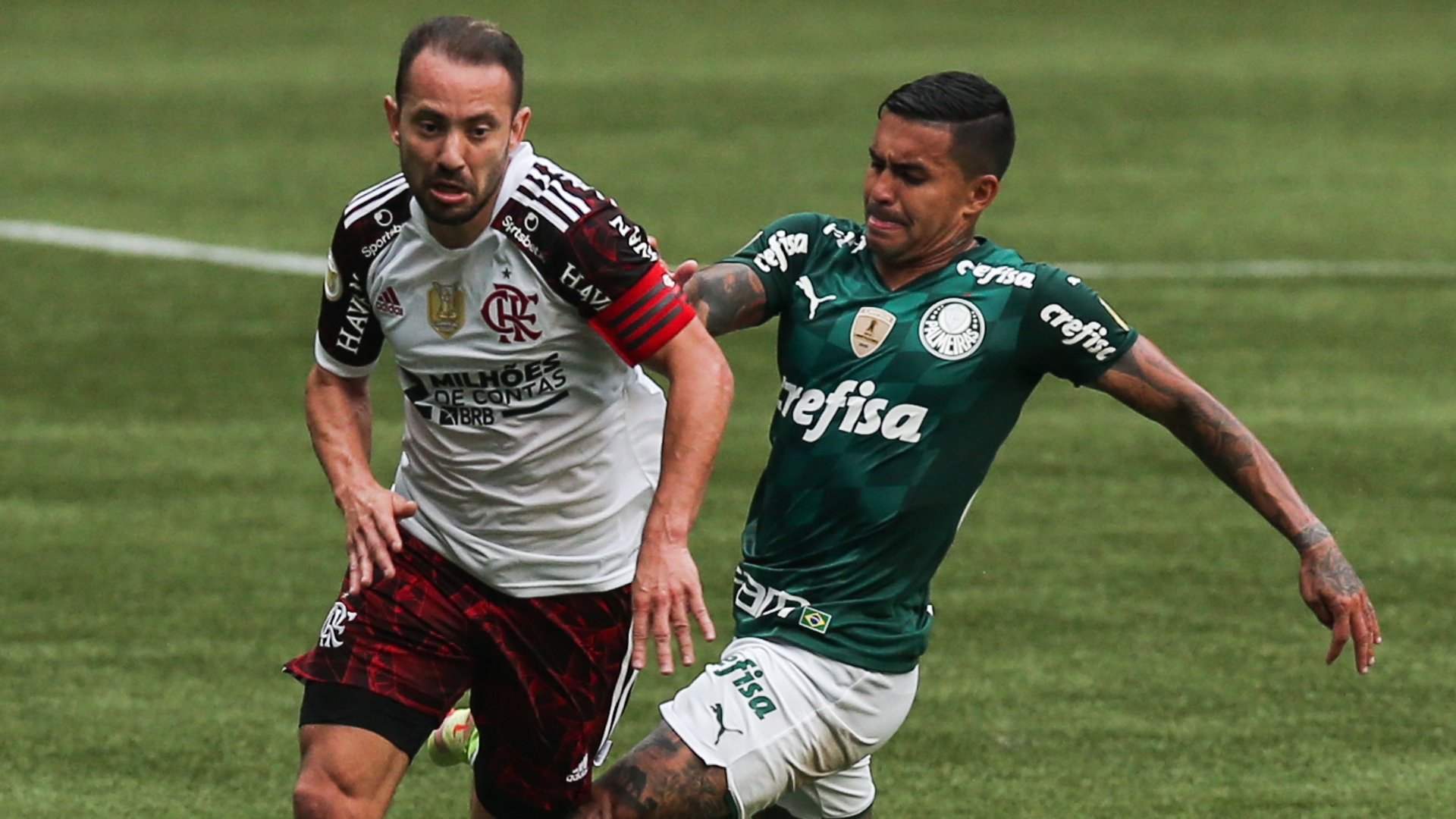 Dois jogadores de futebol jogando futebol no campo marcando um